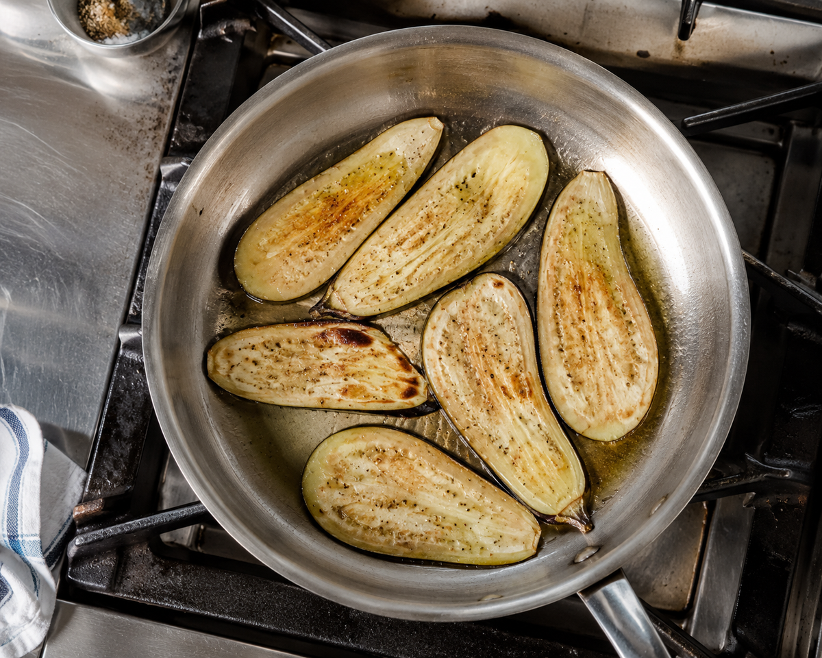 Eggplant slices pan-frying in olive oil for a ciabatta parmigiana recipe in a Singapore kitchen.