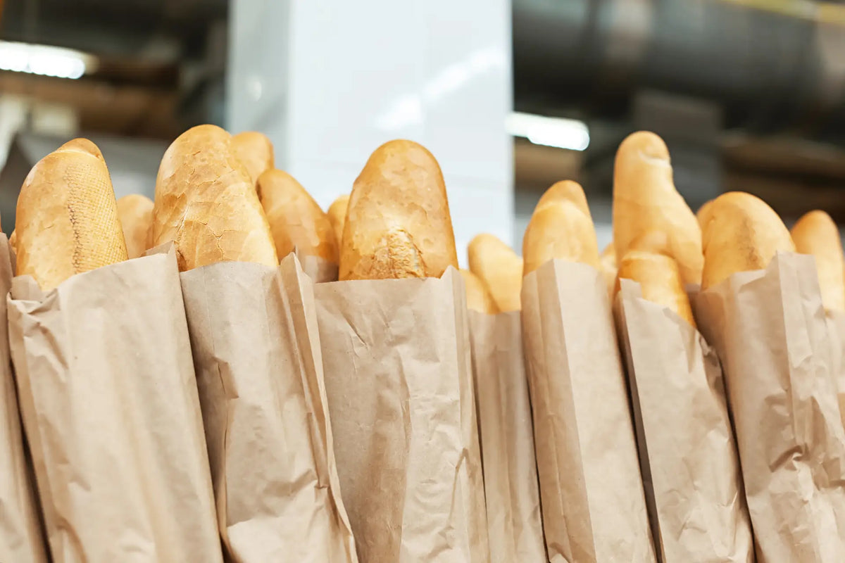 Fresh Délifrance baguettes in paper bags, ready to be paired with curry