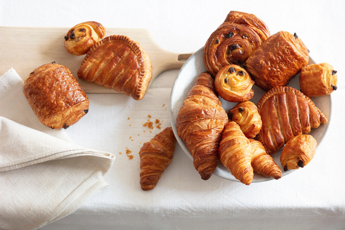 Assorted Delifrance viennoiserie pastries including croissants, pain au chocolat, and fruit danishes on a plate