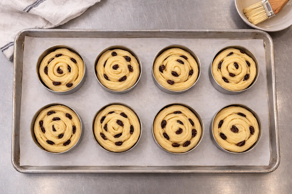 Pain au raisin prepared in metal rings before baking for an easter roll recipe