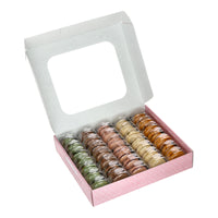 An open box of Délifrance Mini Macarons, revealing the five flavours: Chocolate, Pistachio, Raspberry, Vanilla, and Salted Butter Caramel. Gluten-free and Halal